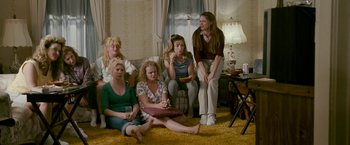 Movie still from “The Fighter” (2010), directed by David O. Russell – A group of women sitting on the floor in a living room; Wide shot, High angle