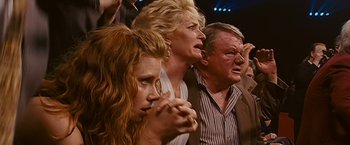 Movie still from “The Fighter” (2010), directed by David O. Russell – A group of people that are standing in a room; Close Up shot, High angle