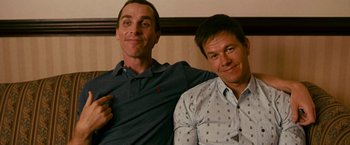 Movie still from “The Fighter” (2010), directed by David O. Russell – A couple of men sitting next to each other; Medium shot, Low angle