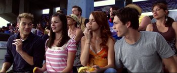 Movie still from “The Final Destination” (2009), directed by David R. Ellis – A group of young people sitting in a crowd; Medium shot, Over the shoulder angle