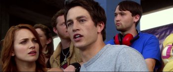 Movie still from “The Final Destination” (2009), directed by David R. Ellis – A young man is talking on a cell phone while two other young men are watching; Close Up shot, Over the shoulder angle