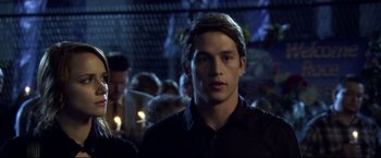 Movie still from “The Final Destination” (2009), directed by David R. Ellis – A man in a black shirt is standing in a crowd; Close Up shot, Over the shoulder angle