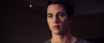 Movie still from “The Final Destination” (2009), directed by David R. Ellis – A young man's face in a dark room; Close Up shot, Over the shoulder angle