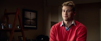 Movie still from “The Final Destination” (2009), directed by David R. Ellis – A man in a red sweater sitting in front of a painting; Close Up shot, Over the shoulder angle