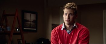 Movie still from “The Final Destination” (2009), directed by David R. Ellis – A man in a red sweater is sitting in a room; Close Up shot, Over the shoulder angle