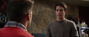 Movie still from “The Final Destination” (2009), directed by David R. Ellis – A man standing in front of a mirror in front of a stone wall; Medium shot, Over the shoulder angle