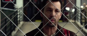 Movie still from “The Final Destination” (2009), directed by David R. Ellis – A person behind a metal fence; Close Up shot, Over the shoulder angle