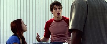 Movie still from “The Final Destination” (2009), directed by David R. Ellis – A young man talking to another man while sitting on a chair; Medium shot, Over the shoulder angle