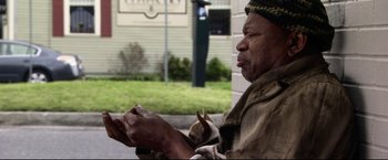 Movie still from “The Final Destination” (2009), directed by David R. Ellis – A man sitting on the side of the road with a dog; Medium shot, Over the shoulder angle