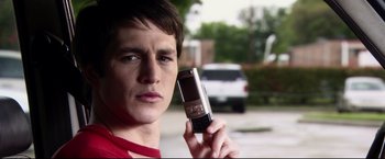 Movie still from “The Final Destination” (2009), directed by David R. Ellis – A man holding up a cell phone in his hand; Close Up shot, Low angle