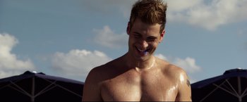 Movie still from “The Final Destination” (2009), directed by David R. Ellis – A shirtless man with no shirt is smiling for the camera; Close Up shot, Over the shoulder angle