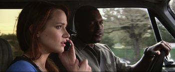 Movie still from “The Final Destination” (2009), directed by David R. Ellis – A man and a woman in a car talking on a cell phone; Close Up shot, Over the shoulder angle