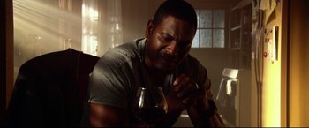 Movie still from “The Final Destination” (2009), directed by David R. Ellis – A man sitting in front of a glass of wine; Close Up shot, Low angle