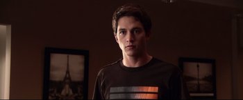 Movie still from “The Final Destination” (2009), directed by David R. Ellis – A man in a brown shirt is standing in a room; Medium shot, Low angle