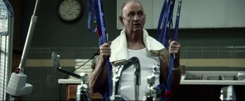 Movie still from “The Final Destination” (2009), directed by David R. Ellis – An older man holding a towel around his neck; Medium shot, Low angle