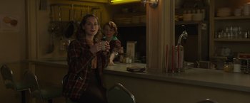 Movie still from “The Finest Hours” (2016), directed by Craig Gillespie – A woman sitting in front of a mirror holding a drink; Medium shot, Over the shoulder angle