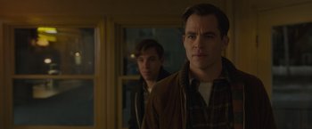 Movie still from “The Finest Hours” (2016), directed by Craig Gillespie – Two men standing next to each other in front of a window; Medium shot, Over the shoulder angle