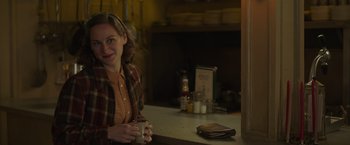 Movie still from “The Finest Hours” (2016), directed by Craig Gillespie – A woman sitting at a counter holding a cup; Medium shot, Over the shoulder angle