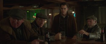 Movie still from “The Finest Hours” (2016), directed by Craig Gillespie – Two men sitting at a table with a beer; Medium shot, Over the shoulder angle