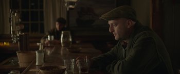 Movie still from “The Finest Hours” (2016), directed by Craig Gillespie – A man sitting at a table with two glasses of beer; Medium shot, Over the shoulder angle
