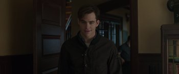 Movie still from “The Finest Hours” (2016), directed by Craig Gillespie – A man in a brown jacket standing next to a door way; Medium shot, Over the shoulder angle