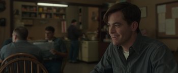 Movie still from “The Finest Hours” (2016), directed by Craig Gillespie – A man sitting at a table in front of another man; Medium shot, Over the shoulder angle