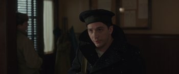 Movie still from “The Finest Hours” (2016), directed by Craig Gillespie – A man wearing a black coat and a hat; Close Up shot, Over the shoulder angle