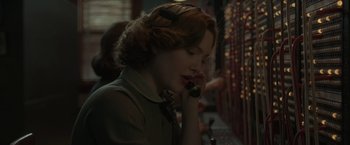 Movie still from “The Finest Hours” (2016), directed by Craig Gillespie – A woman talking on a phone while wearing headphones; Close Up shot, Low angle