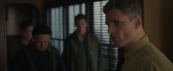 Movie still from “The Finest Hours” (2016), directed by Craig Gillespie – A man standing next to another man in front of a window; Close Up shot, Over the shoulder angle