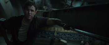 Movie still from “The Finest Hours” (2016), directed by Craig Gillespie – A man in a black shirt holding a pair of scissors; Medium shot, Low angle