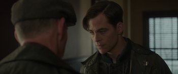 Movie still from “The Finest Hours” (2016), directed by Craig Gillespie – A man in a hat and jacket looking at another man in a hat; Close Up shot, Over the shoulder angle