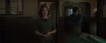 Movie still from “The Finest Hours” (2016), directed by Craig Gillespie – A woman standing in front of a mirror in front of a door; Medium shot, Over the shoulder angle