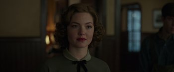 Movie still from “The Finest Hours” (2016), directed by Craig Gillespie – A young woman with curly brown hair wearing a green shirt; Close Up shot, Over the shoulder angle