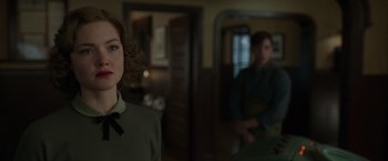 Movie still from “The Finest Hours” (2016), directed by Craig Gillespie – A woman standing next to a man in a room; Close Up shot, Over the shoulder angle