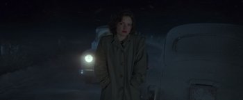 Movie still from “The Finest Hours” (2016), directed by Craig Gillespie – A woman standing in the dark in a trench coat; Medium shot, Low angle