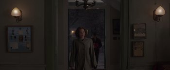 Movie still from “The Finest Hours” (2016), directed by Craig Gillespie – A woman standing in front of a door in a house; Wide shot, High angle