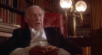 Movie still from “The Great Train Robbery” (1978), directed by Michael Crichton – An older man sitting in a chair in a library; Close Up shot, Low angle