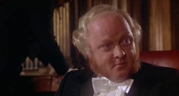 Movie still from “The Great Train Robbery” (1978), directed by Michael Crichton – A man with a beard and a white bow tie; Close Up shot, High angle