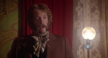 Movie still from “The Great Train Robbery” (1978), directed by Michael Crichton – A man in a brown suit and a neck tie; Close Up shot, Low angle