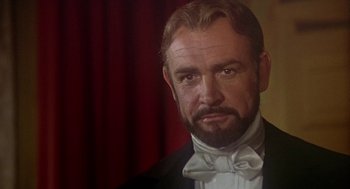 Movie still from “The Great Train Robbery” (1978), directed by Michael Crichton – A person wearing a suit and bow tie; Close Up shot, Over the shoulder angle