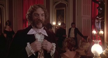 Movie still from “The Great Train Robbery” (1978), directed by Michael Crichton – A man dressed in period clothing holding his tie; Medium shot, Low angle