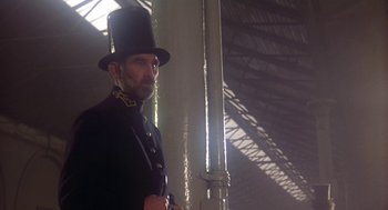 Movie still from “The Great Train Robbery” (1978), directed by Michael Crichton – A man wearing a top hat and a chain around his neck; Medium shot, Low angle