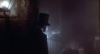 Movie still from “The Great Train Robbery” (1978), directed by Michael Crichton – A man wearing a top hat and a black coat; Wide shot, Low angle