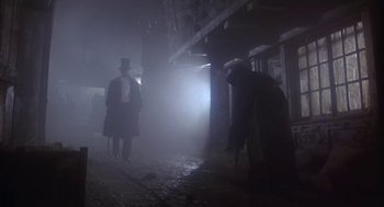 Movie still from “The Great Train Robbery” (1978), directed by Michael Crichton – A man in a top hat is standing next to another man in top hat; Wide shot, Low angle