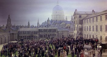 Movie still from “The Great Train Robbery” (1978), directed by Michael Crichton – A crowd of people standing in front of a building; Extreme Wide shot, High angle