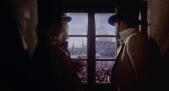 Movie still from “The Great Train Robbery” (1978), directed by Michael Crichton – Two men looking out of a window at a crowd of onlookers; Medium shot, Low angle
