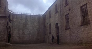 Movie still from “The Great Train Robbery” (1978), directed by Michael Crichton – Two men standing in front of a brick building; Extreme Wide shot, High angle