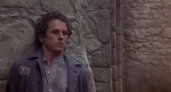 Movie still from “The Great Train Robbery” (1978), directed by Michael Crichton – A man leaning against a stone wall looking to his left; Close Up shot, Low angle