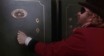 Movie still from “The Great Train Robbery” (1978), directed by Michael Crichton – A man in a red jacket is opening a door; Close Up shot, Over the shoulder angle