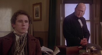 Movie still from “The Great Train Robbery” (1978), directed by Michael Crichton – Two men are sitting at a desk in a room; Medium shot, Over the shoulder angle